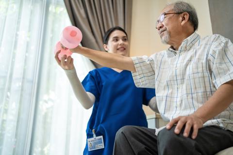 Female nurse helping an older man exercise